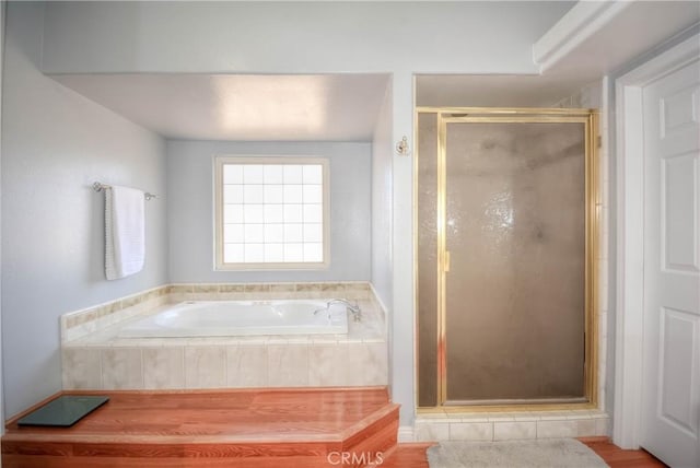 bathroom with hardwood / wood-style floors and separate shower and tub