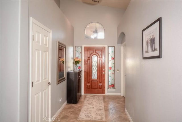 entrance foyer featuring high vaulted ceiling and light tile patterned flooring