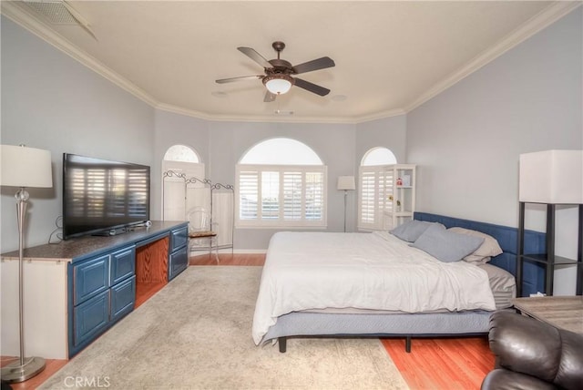 bedroom with ceiling fan, wood-type flooring, and ornamental molding