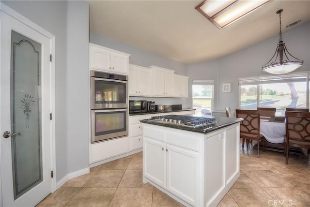 kitchen with white cabinetry, a center island, hanging light fixtures, stainless steel appliances, and lofted ceiling