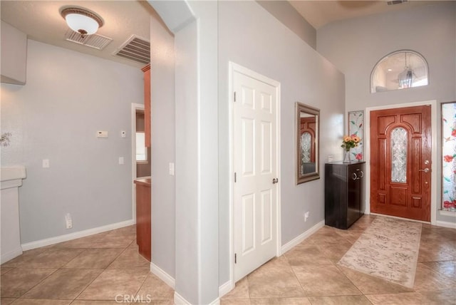 tiled entryway featuring high vaulted ceiling and a healthy amount of sunlight