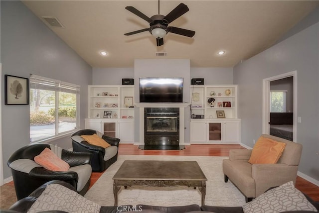 living room featuring ceiling fan, light hardwood / wood-style floors, and vaulted ceiling