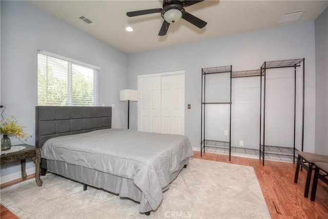 bedroom with hardwood / wood-style flooring, ceiling fan, and a closet