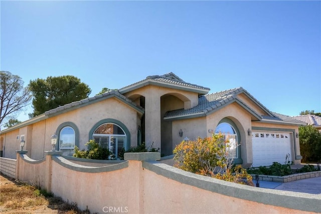 mediterranean / spanish home with a garage