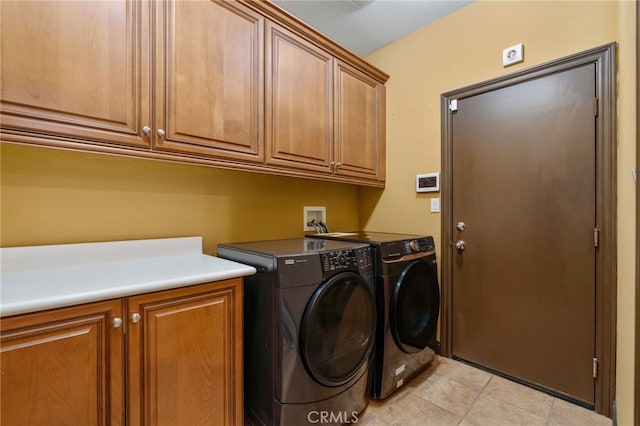 laundry area featuring cabinets, light tile patterned floors, a textured ceiling, and washer and clothes dryer