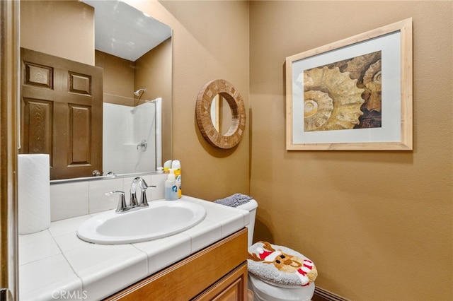 bathroom featuring a shower, vanity, and toilet