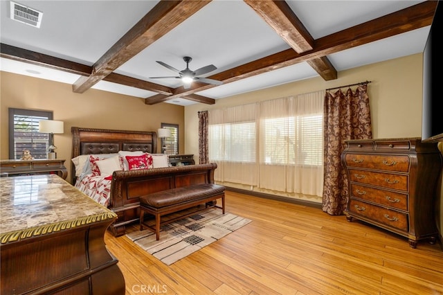 bedroom featuring ceiling fan, light hardwood / wood-style floors, and beam ceiling