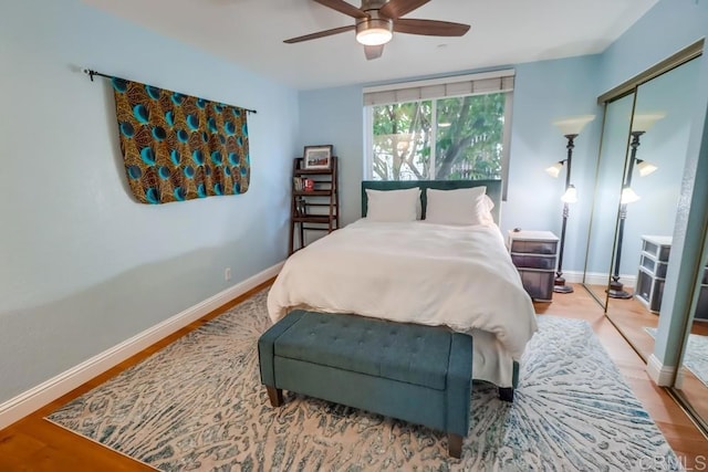 bedroom with ceiling fan, a closet, and light hardwood / wood-style flooring