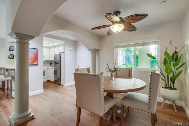 dining space featuring ceiling fan, light hardwood / wood-style floors, and ornate columns