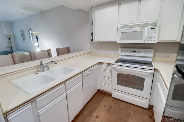 kitchen with white appliances, sink, kitchen peninsula, light hardwood / wood-style flooring, and white cabinetry