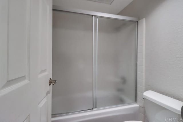 bathroom with toilet and enclosed tub / shower combo