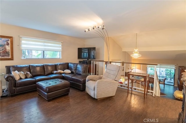 living room featuring dark wood-type flooring, vaulted ceiling, and an inviting chandelier