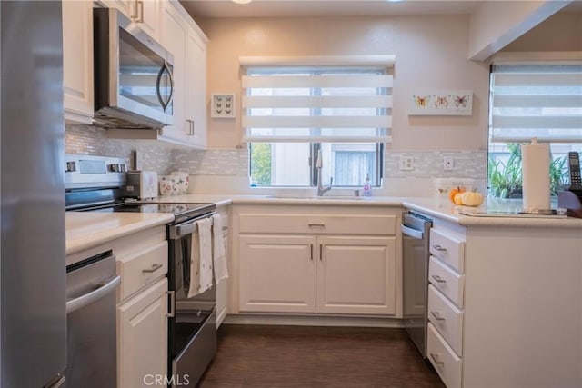 kitchen with appliances with stainless steel finishes, tasteful backsplash, white cabinetry, and sink