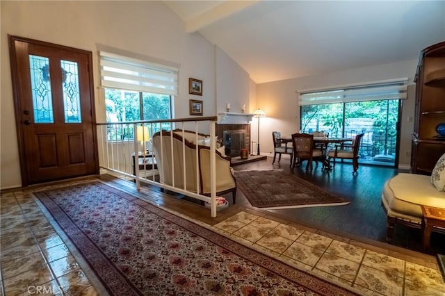 foyer entrance with vaulted ceiling with beams, wood-type flooring, and a wealth of natural light