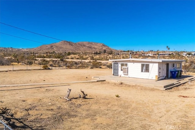 rear view of property with a mountain view and a patio area