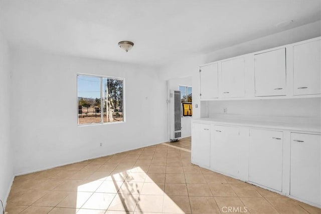 kitchen featuring light tile patterned flooring and white cabinetry