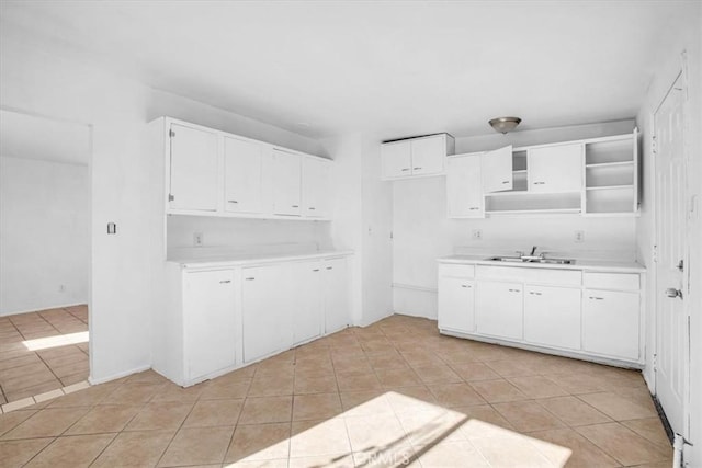 kitchen featuring white cabinetry, light tile patterned floors, and sink