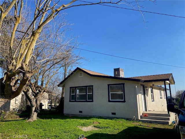 back of house with a lawn