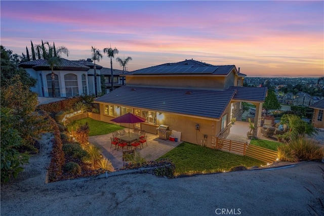 view of front of house featuring a patio and solar panels