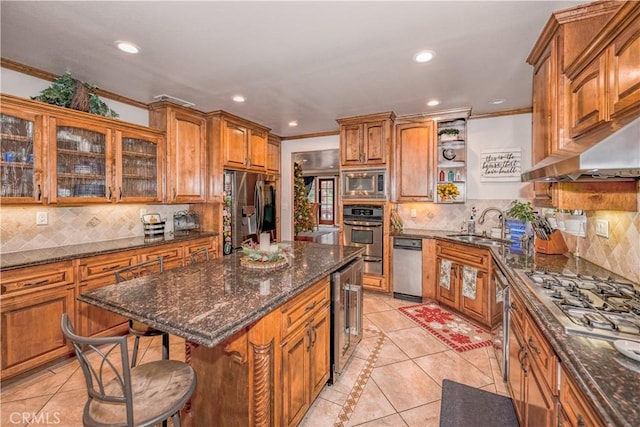 kitchen with sink, wine cooler, light tile patterned floors, appliances with stainless steel finishes, and a kitchen island