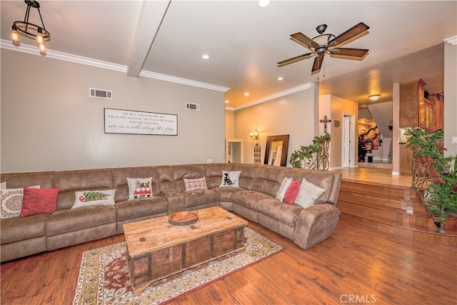 living room with beamed ceiling, ceiling fan, wood-type flooring, and ornamental molding