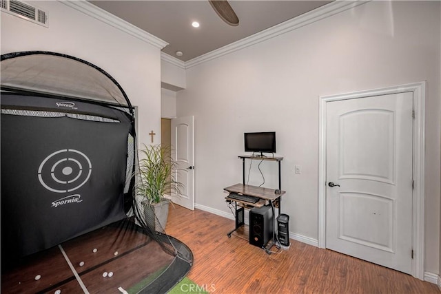 workout area with hardwood / wood-style flooring and crown molding