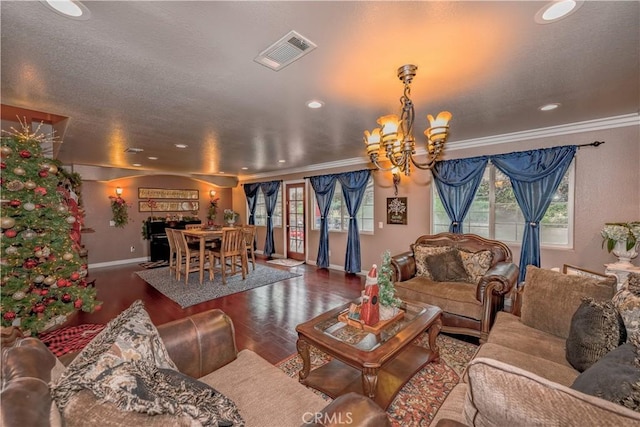 living room featuring dark hardwood / wood-style flooring, an inviting chandelier, and crown molding