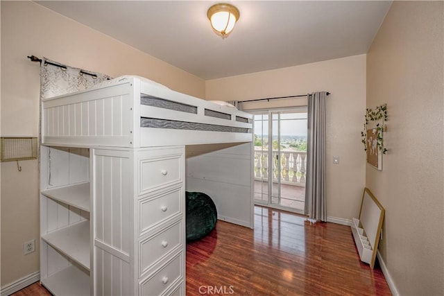 bedroom with access to outside and dark hardwood / wood-style floors