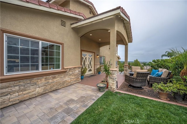 entrance to property featuring outdoor lounge area and a patio