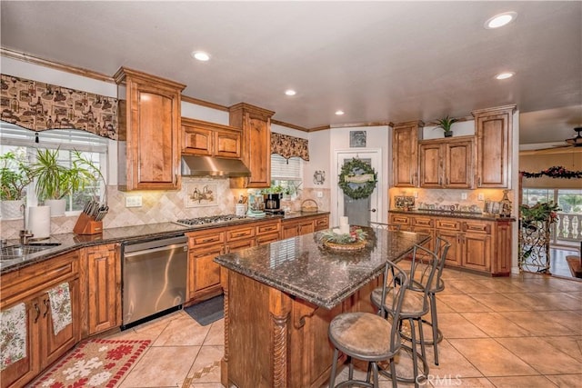 kitchen with a center island, sink, stainless steel appliances, and a wealth of natural light