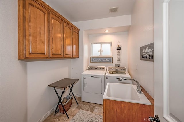 laundry area featuring washer and dryer, cabinets, and sink