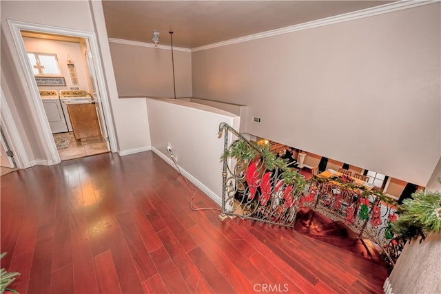 hall with hardwood / wood-style floors, washing machine and dryer, and ornamental molding