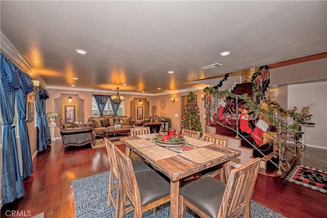 dining room with ornamental molding, dark wood-type flooring, and a chandelier