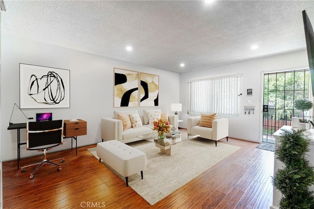 living room featuring a textured ceiling and hardwood / wood-style flooring