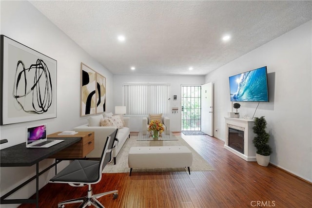 living room featuring a textured ceiling and wood-type flooring