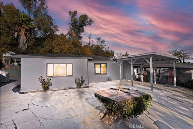 back house at dusk featuring a patio