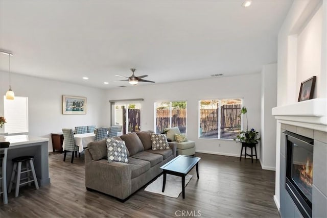 living room featuring ceiling fan and dark hardwood / wood-style flooring