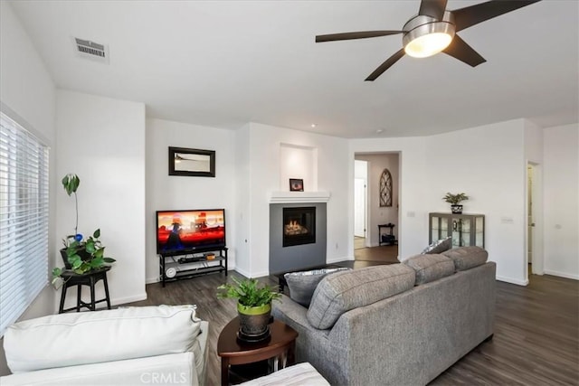 living room featuring dark hardwood / wood-style flooring and ceiling fan