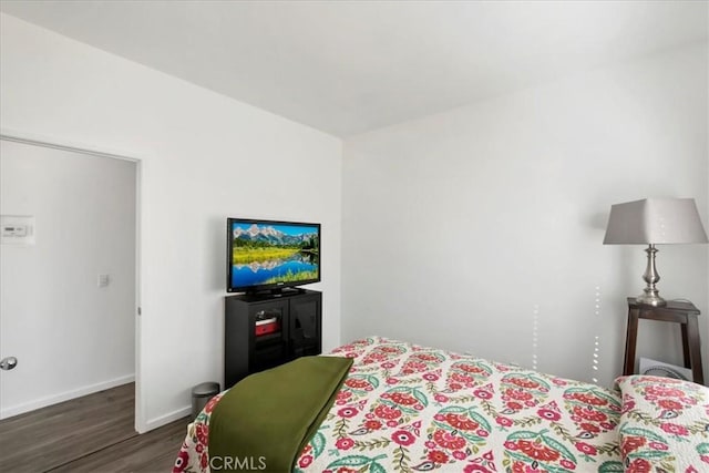 bedroom with dark wood-type flooring