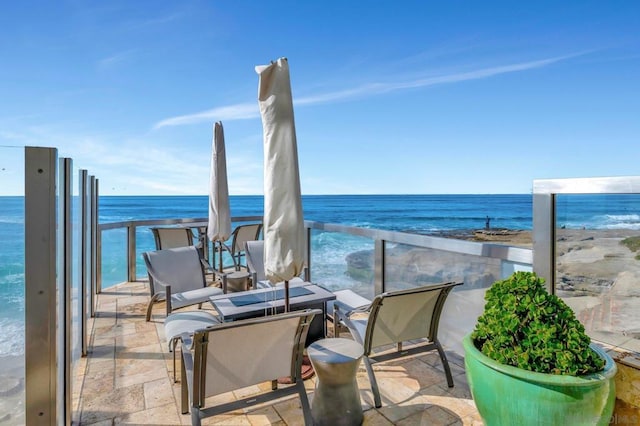 balcony with a water view and a beach view