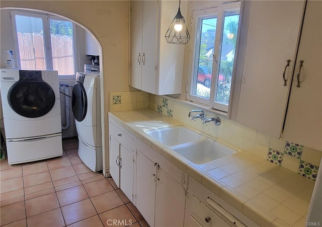 laundry room featuring a wealth of natural light, sink, and washer and dryer