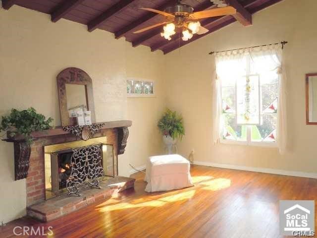 sitting room featuring wooden ceiling, lofted ceiling with beams, hardwood / wood-style flooring, ceiling fan, and a fireplace