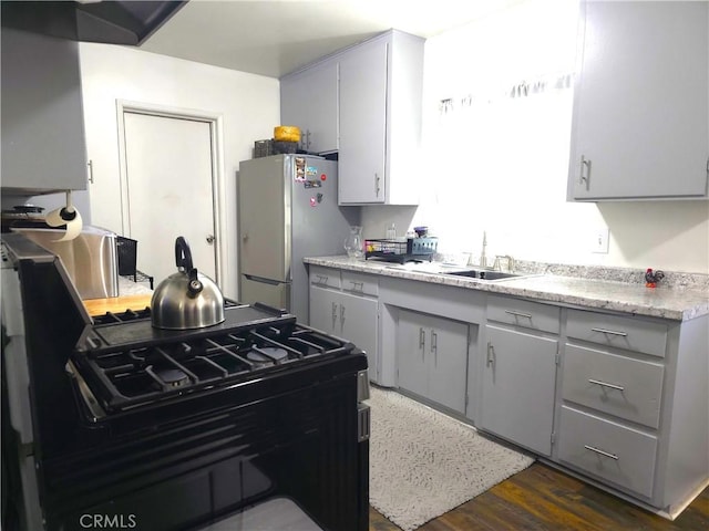 kitchen with stainless steel fridge, sink, black range with gas cooktop, and dark wood-type flooring