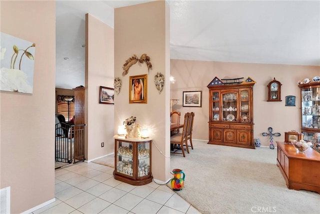 corridor featuring light colored carpet and vaulted ceiling