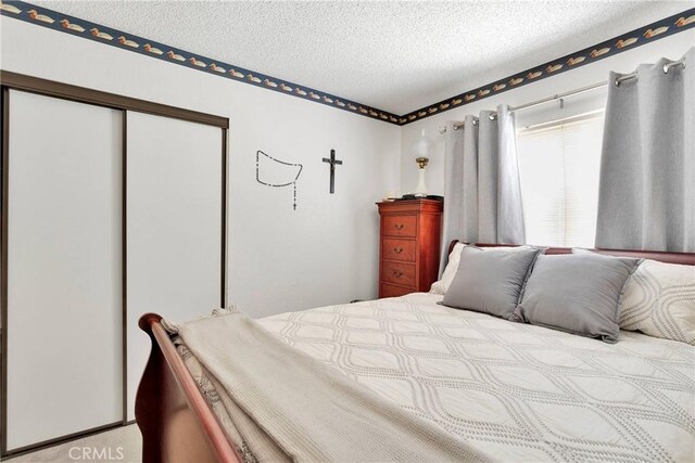 bedroom featuring a textured ceiling and a closet