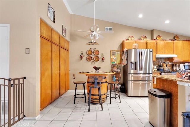 kitchen featuring ceiling fan, a breakfast bar, light tile patterned floors, and stainless steel appliances