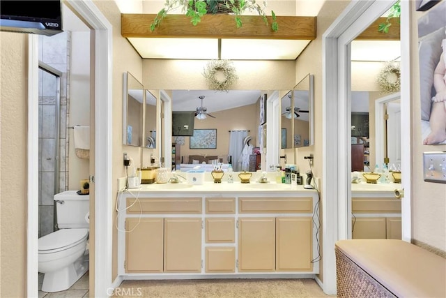 bathroom with ceiling fan, tile patterned floors, toilet, a shower with door, and vanity