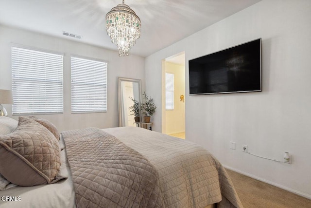 carpeted bedroom with an inviting chandelier