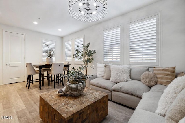 living room with light hardwood / wood-style floors and a notable chandelier