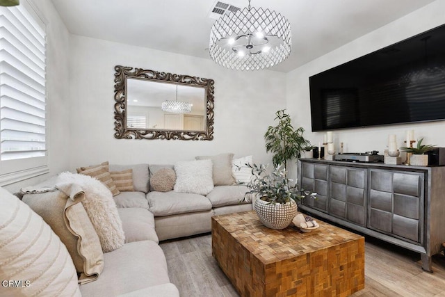 living room featuring a notable chandelier and light hardwood / wood-style floors